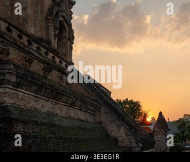 Chiang mai, Thaïlande - 3 mars 2020 : les murs de briques et l'escalier de l'ancien chedi à Wat Chedi Luang brillent dans la lumière du soir. Banque D'Images