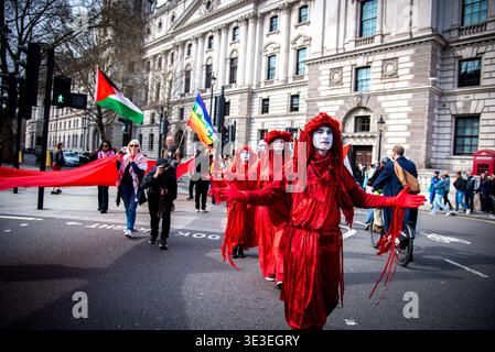 Londres, Royaume-Uni. 22 mars 2026. Manifestants vus vêtus de costumes rouges pendant le pèlerinage pour la Palestine 2026 sur la place du Parlement. Pilgrimage4Palestine est née en 2025. Dans un extraordinaire spectacle d'empathie et de résistance, Peter Oswald, poète et dramaturge du Sud-Ouest, a marché 150 miles de Bristol à London Parliament Square tout en jeûnant pour le Ramadan. Crédit : SOPA images Limited/Alamy Live News Banque D'Images