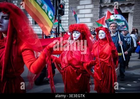 Londres, Royaume-Uni. 22 mars 2026. Manifestants vus vêtus de costumes rouges pendant le pèlerinage pour la Palestine 2026 sur la place du Parlement. Pilgrimage4Palestine est née en 2025. Dans un extraordinaire spectacle d'empathie et de résistance, Peter Oswald, poète et dramaturge du Sud-Ouest, a marché 150 miles de Bristol à London Parliament Square tout en jeûnant pour le Ramadan. Crédit : SOPA images Limited/Alamy Live News Banque D'Images