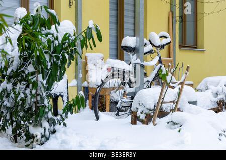 Vélo couvert de neige près de la maison hiver scène urbaine temps froid style de vie résidentiel Banque D'Images