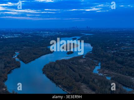 La vue aérienne de la Vistule près de Varsovie montre des canaux tressés et de longues îles boisées à travers une plaine inondable sombre, une lumière douce du soir et un faible Banque D'Images