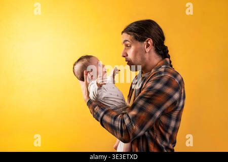 Père tenant bébé nouveau-né et regardant avec amour Banque D'Images