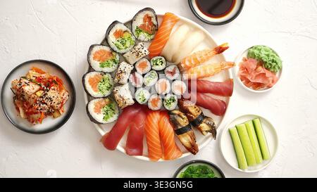 Grand plateau de sushi avec des rouleaux de nigiri et de maki sur fond blanc Banque D'Images
