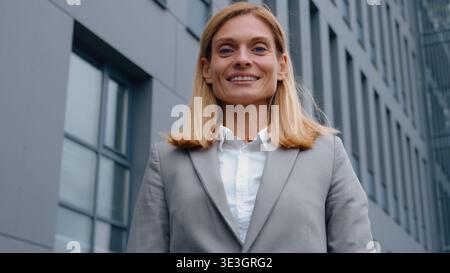 Portrait féminin femme d'affaires adulte caucasienne regardant autour dans la ville souriant heureux à la caméra femme d'affaires d'âge moyen cadre féminin dans le centre-ville Banque D'Images