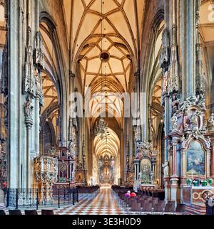 Les visiteurs explorent l'intérieur de la cathédrale d'Étienne à Vienne, en Autriche, en observant le design gothique détaillé et religieux Banque D'Images