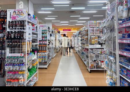 Une femme fait ses courses dans un magasin Daiso de 100 yens à Shinjuku, alors que le détaillant à prix réduits japonais continue d’étendre sa présence mondiale dans un contexte de forte popularité à l’étranger. Connu pour sa large gamme d'articles ménagers abordables, Daiso offre des produits comprenant des ustensiles de cuisine, vaisselle, papeterie, cosmétiques, fournitures de nettoyage, articles de stockage, outils de jardinage, collations et produits saisonniers, attirant les clients avec sa variété et ses prix bas. La société exploite des milliers de magasins à travers le monde en Asie, en Amérique du Nord, en Europe et au moyen-Orient, ce qui en fait l’une des marques de vente au détail les plus reconnaissables du Japon à l’étranger. Banque D'Images