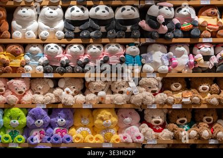Jouets en peluche pour enfants sur les étagères dans Miniso Brand Store. Une vitrine lumineuse avec des jouets pour enfants dans un magasin. Minsk, Biélorussie - 16 décembre 2025 Banque D'Images