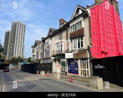 Boutiques et maisons abandonnées à Woking avec des tours de grande hauteur en arrière-plan, régénération urbaine et contraste de réaménagement, Woking, Surrey, Angleterre Banque D'Images