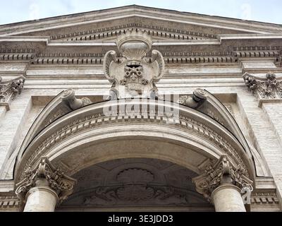 Chiesa di Sant'Andrea al Quirinale. Rome, Italie. Détail baroque montrant la corniche, l'arc et les colonnes corinthiennes sous le ciel nuageux. Banque D'Images