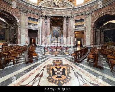 Chiesa di Sant'Andrea al Quirinale. Rome, Italie. Intérieur de l'église baroque avec marbre rouge, bancs en bois et écusson au sol. Banque D'Images