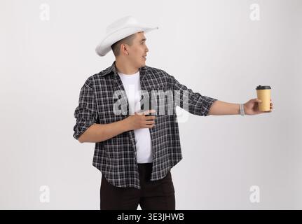 Homme en chapeau de cow-boy tenant une tasse de café Banque D'Images