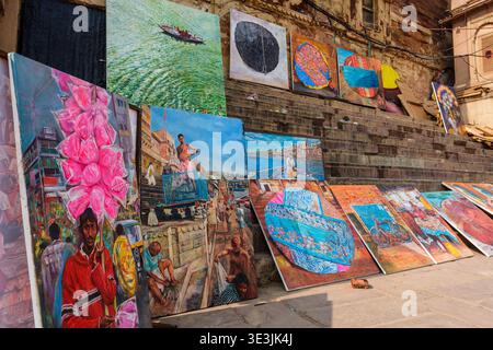 De nombreuses peintures colorées sur toile sont exposées à la vente sur les marches de pierre du Varanasi Dashashwamedh Ghat près du bord du Gange. Banque D'Images