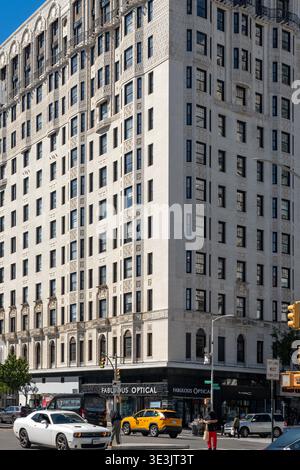 New York, NY, États-Unis - Un grand bâtiment blanc avec des détails architecturaux ornés se dresse au coin d'une rue à Harlem Banque D'Images