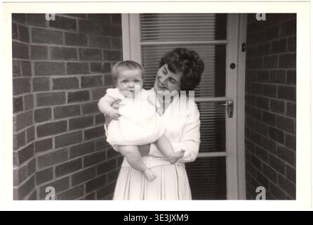 Mère et bébé devant leur maison à Beverley, Yorkshire, Angleterre Royaume-Uni en 1962 Banque D'Images