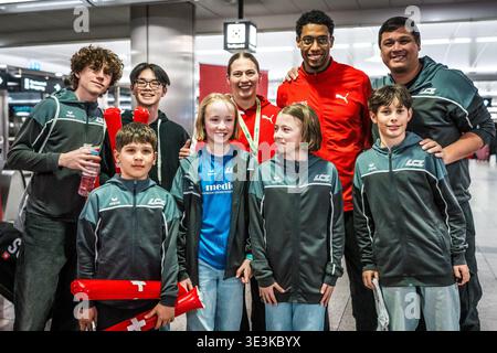 ZURICH, SUISSE - 23 MARS : Angelica Moser, rangée arrière, au centre, et Ivan Pelizza, rangée arrière deuxième à partir de la droite, reviennent des Championnats du monde d'athlétisme en salle et sont accueillis par les fans suisses à l'aéroport de Kloten le 23 mars 2026 à Zurich, Suisse. Banque D'Images