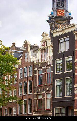 Des maisons de canal hollandaises traditionnelles avec des façades à pignons distinctives bordent une rue à Amsterdam, pays-Bas. Les bâtiments historiques en briques sont ornés Banque D'Images