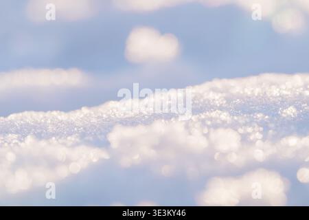 Paysage hivernal serein, cristaux de neige étincelants captent le soleil bas, créant un spectacle éblouissant de lumière et d'ombre. Le ciel bleu doux fournit un gent Banque D'Images