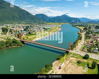 Vue aérienne du pont suspendu historique Président Ibanez sur la rivière Aysen, Patagonie, Chili. Paysage urbain avec montagnes et rivière en été. Banque D'Images