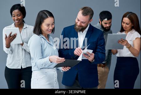 Dossier, réunion et parler avec des gens d'affaires en studio ensemble pour la discussion ou le rapport. Diversité, documents et travail d'équipe avec le groupe d'employés sur Banque D'Images
