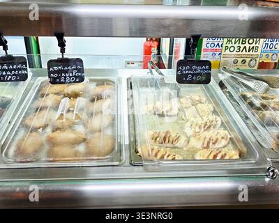 Orenbourg, Russie - 22 août 2025 : les gens peuvent voir plusieurs plateaux qui contiennent différents types de plats cuisinés sur un marché local pendant l'heure du déjeuner. Banque D'Images