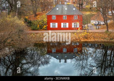 Maison rouge avec volets blancs reflétés dans l'eau du lac, paysage d'automne à Copenhague Banque D'Images