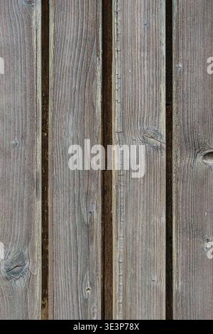 Gros plan de planches en bois gris altérées avec grain visible et interstices étroits. Surface rustique minimale avec lignes verticales et texture naturelle. Banque D'Images