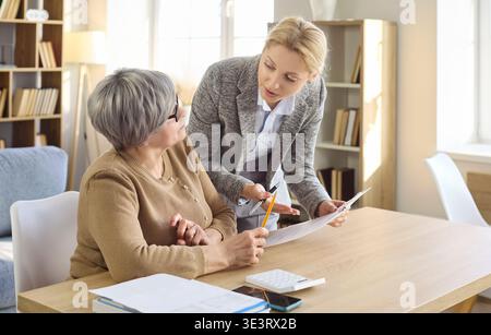 Femme senior rencontrant un conseiller financier à la maison pour la paperasse et la planification Banque D'Images