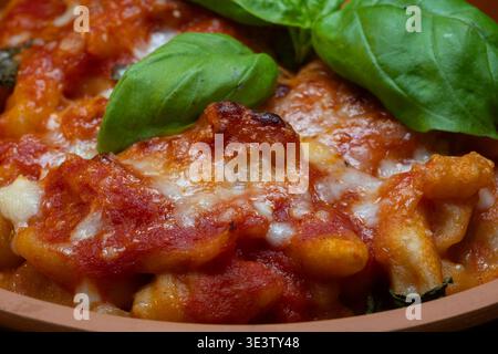 Gnocchi alla sorrentina sont des gnocchi de pommes de terre garni d'une sauce tomate simple aromatisée au basilic, enrichie de mozzarella filamenteuse et de parmesan, et t Banque D'Images