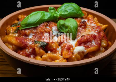 Gnocchi alla sorrentina sont des gnocchi de pommes de terre garni d'une sauce tomate simple aromatisée au basilic, enrichie de mozzarella filamenteuse et de parmesan, et t Banque D'Images