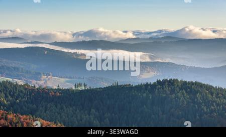 Vue depuis le sommet du Belchen (1414m) sur les collines de la Forêt Noire à la lumière du matin, brouillard dans la vallée, nuages se déplaçant sur le mountai Banque D'Images