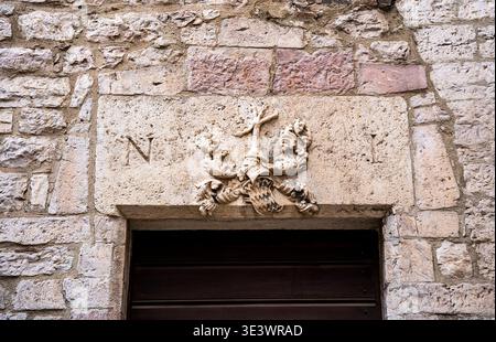Bouclier héraldique de la famille noble SCIRI avec une crête de griffe de coq sculptée sur le linteau au-dessus de l'entrée, le long de la via dei priori à Pérouse, Italie Banque D'Images