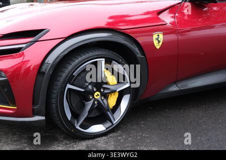 Gros plan de la roue rouge Ferrari Purosangue FUV et de l'écusson mettant en valeur un design de luxe performant, des étriers de frein jaunes et la marque du cheval. Banque D'Images