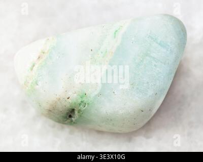 Plan macro d’un échantillon de roche naturelle â€” pierre gemme aragonite verte polie sur fond de marbre blanc de la mine Katanga au Congo Banque D'Images