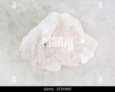 Plan macro d'un échantillon de roche naturelle de pierre de barytine brute sur fond de marbre blanc Banque D'Images