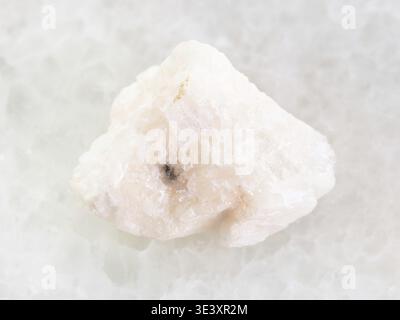 Plan macro d'un échantillon de roche naturelle de pierre de barytine brute sur fond de marbre blanc Banque D'Images