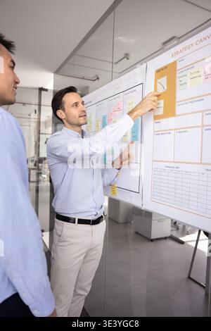 Mentor adulte expérimenté expliquant les idées de planification à un collègue plus jeune Banque D'Images