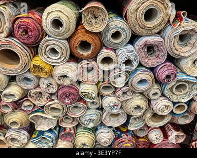 Des rouleaux de tissu de soie coloré sont stockés sur des étagères dans un magasin d'Istanbul. Banque D'Images