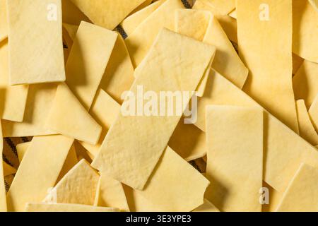 Séchez les nouilles aux œufs larges biologiques dans un bol pour les cuire pour la soupe Banque D'Images