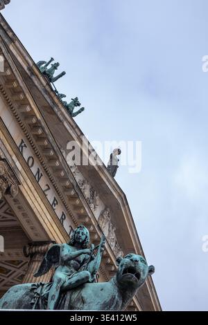 Gros plan de statues ornant la façade d'une salle de concert. Les statues, représentant des figures ailées et un lion, sont rendues dans un b altéré Banque D'Images
