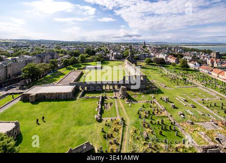 Vue aérienne panoramique sur les ruines historiques de St Andrews, le cimetière et les champs verts pris de la Tour St Rules, avec la ville, le littoral et le ciel bleu s. Banque D'Images