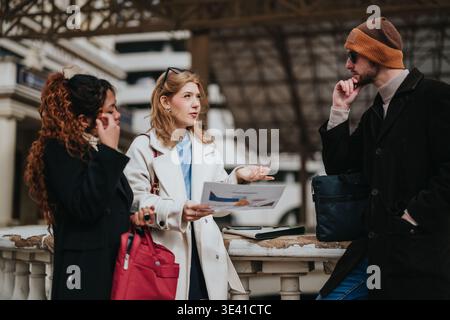 Jeunes professionnels ayant une discussion d'affaires sur les documents de voyage à une station extérieure Banque D'Images
