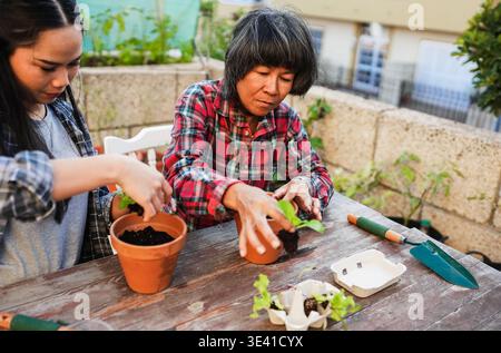 Mère asiatique et fille s'amuser ensemble tout en jardinant sur la terrasse de la maison - style de vie familial, amour et concept de nature Banque D'Images