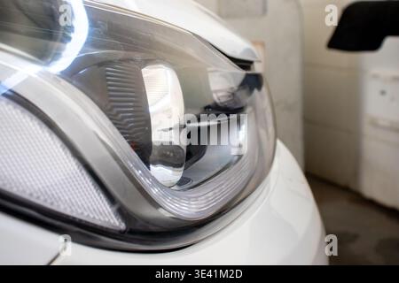 Gros plan d'un phare de voiture blanc avec éclairage LED. Banque D'Images