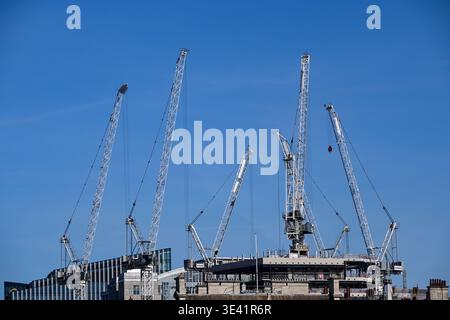 Six grues devant un ciel bleu au-dessus d'un chantier de construction dans le centre de Londres, Angleterre, Royaume-Uni Banque D'Images