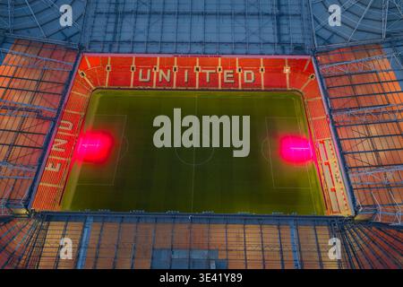 Image aérienne suspendue regardant vers le bas le terrain Old Trafford avec des lampes UV de culture et le lettrage « UNITED » dans les tribunes, Manchester, Royaume-Uni. Banque D'Images