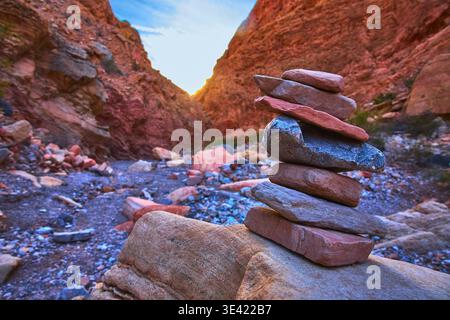 Rock Stack Cairn dans le spectaculaire Red Canyon au coucher du soleil avec paysage naturel accidenté Banque D'Images