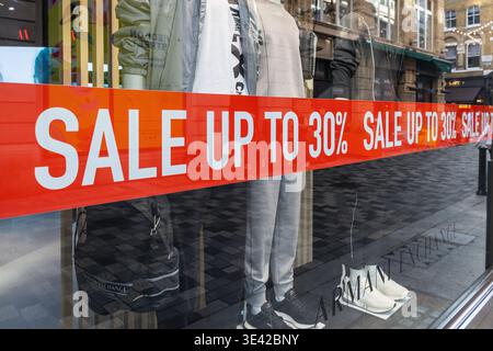Affiche de vente rouge sur une vitrine de magasin de vêtements. Londres, Royaume-Uni, 23 juillet 2023 Banque D'Images