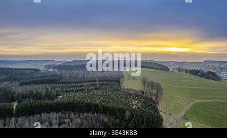 Prise de vue aérienne capture un paysage vibrant avec des champs animés et des forêts luxuriantes à un coucher de soleil pittoresque Banque D'Images