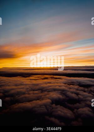 Beau coucher de soleil vibrant ove les nuages comme vu d'une fenêtre passager d'un avion commercial Banque D'Images
