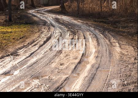 Route de campagne boueuse avec de profondes traces de pneus au début du printemps Banque D'Images